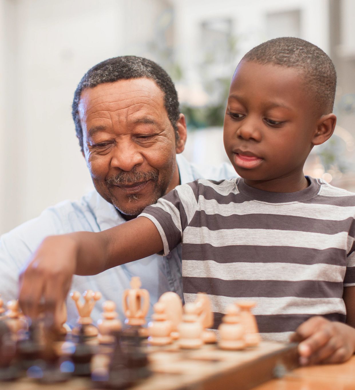 Image of a grandpa and grandson playing chess together