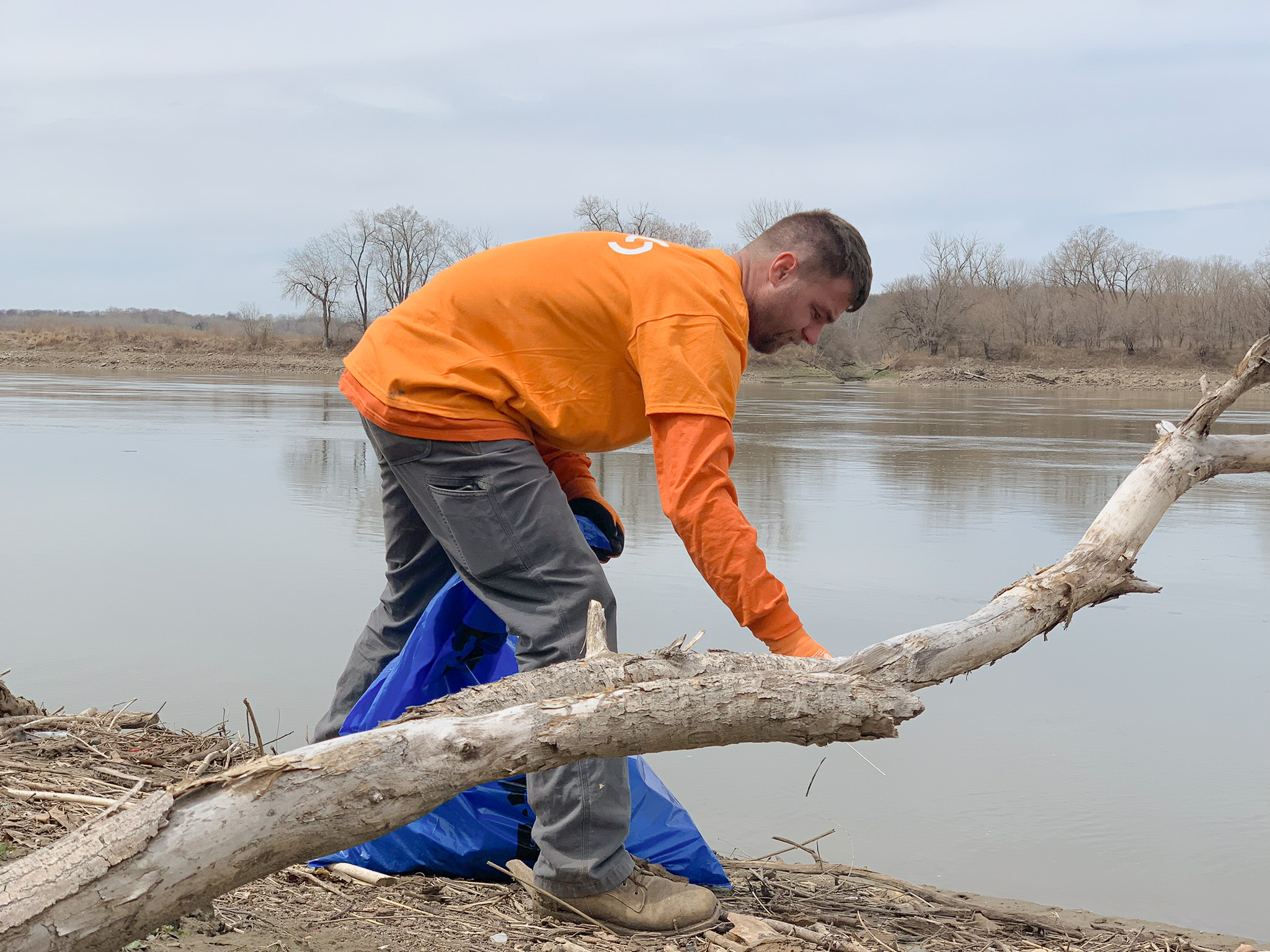 man cleaning brush from river