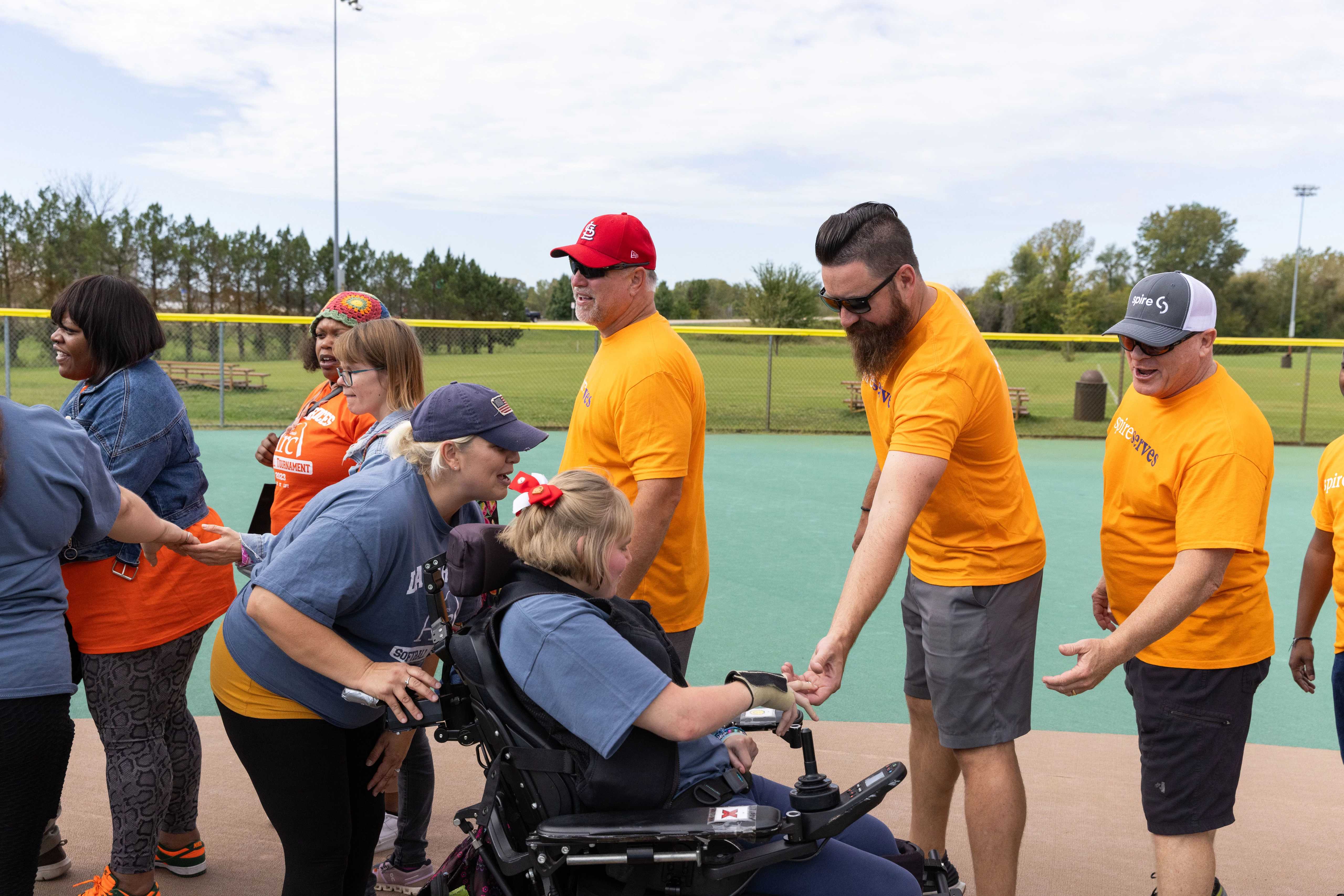 Spire volunteers high fiving person in wheelchair