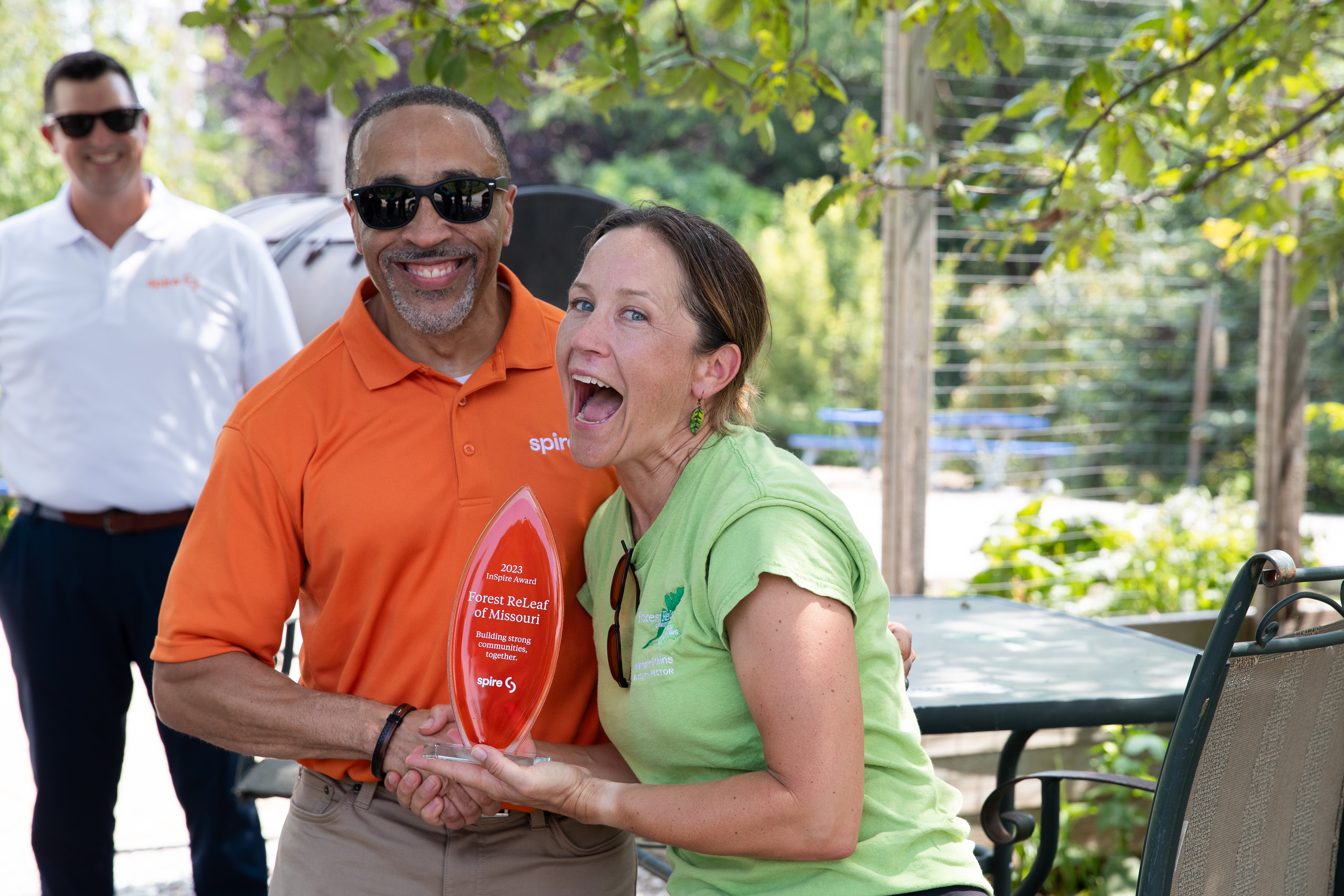 woman is smiling big while receiving an award from Spire employee