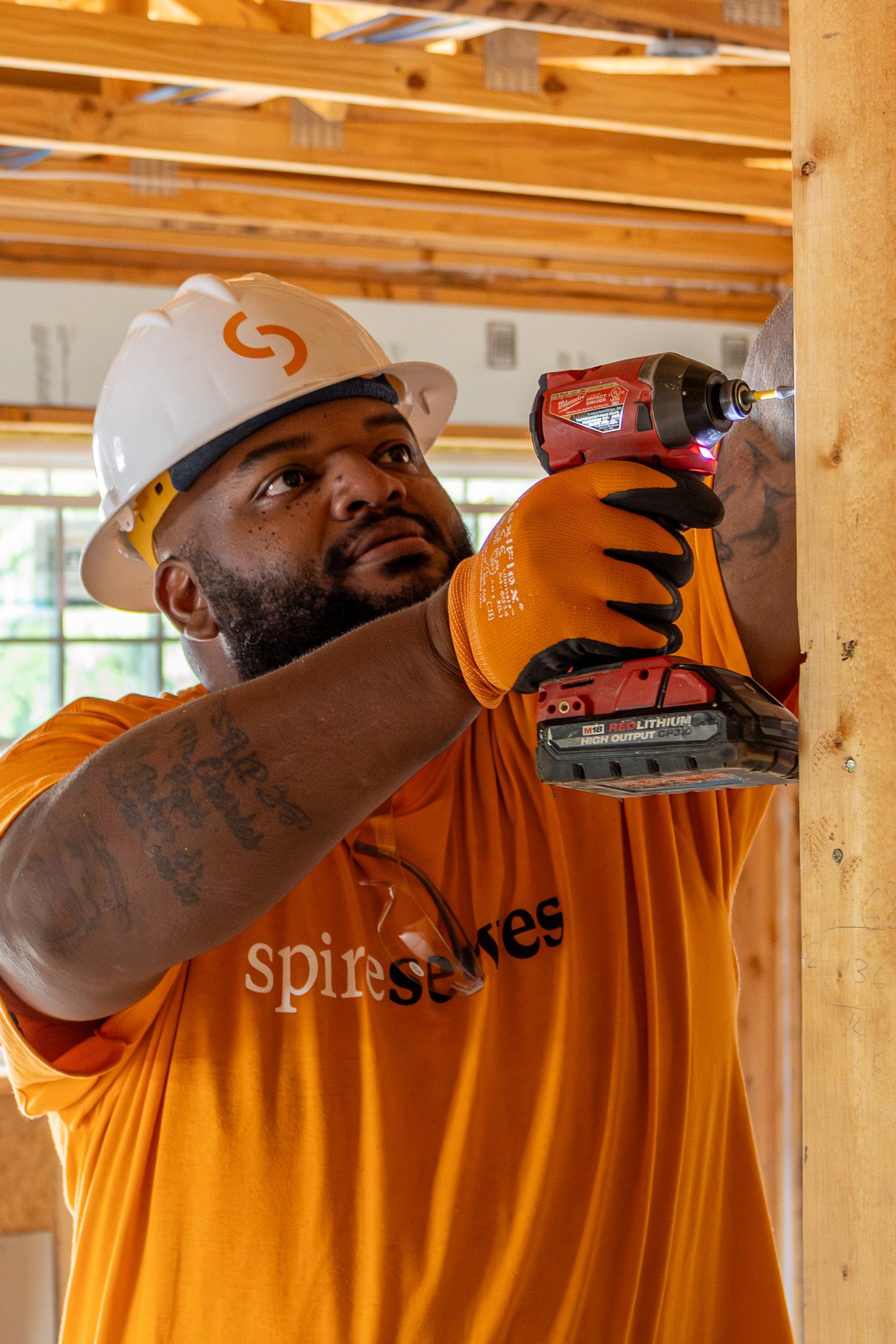 drilling a board on a house frame