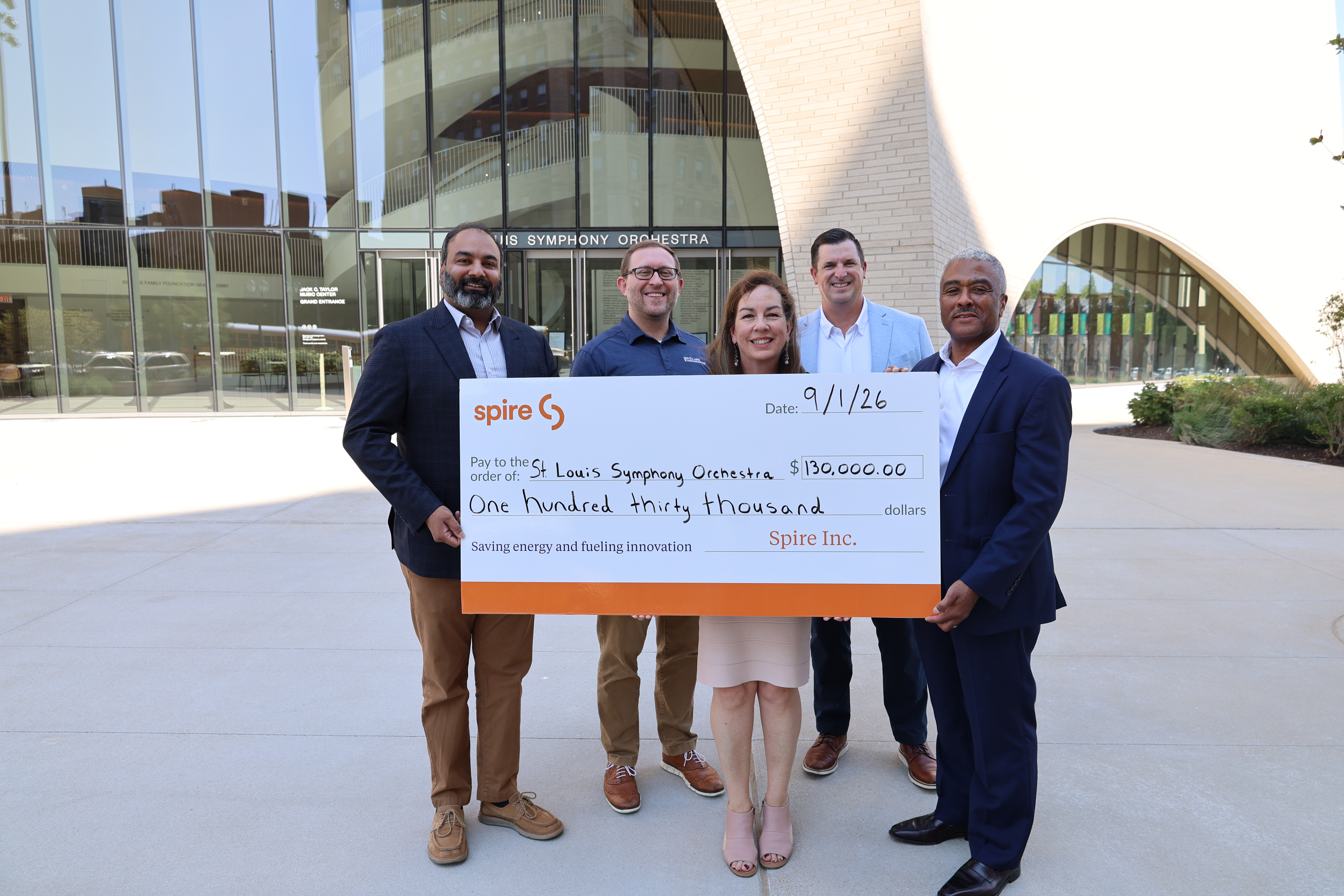 Image of Spire employees presenting large check