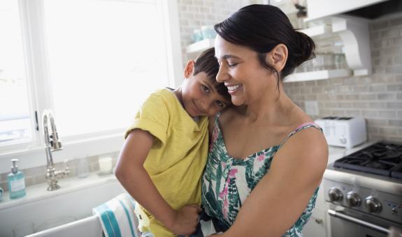 Mom and son hugging in kitchen