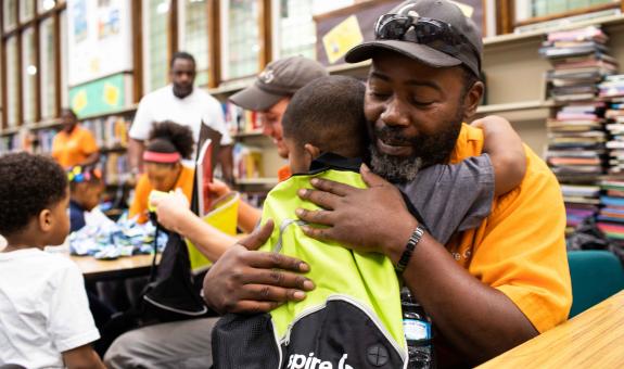 Spire employee delivering backpack to student