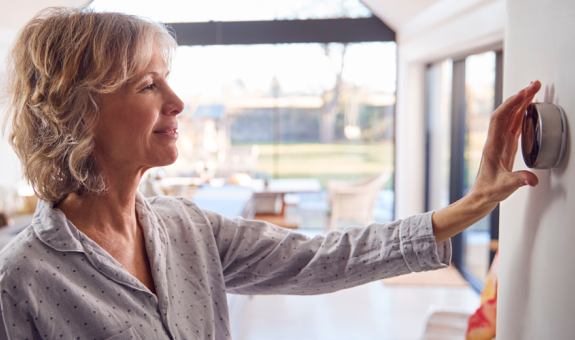 Woman adjusting smart home thermostat