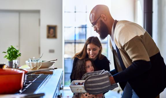 Image of: Father pulling casserole dish out of natural gas oven