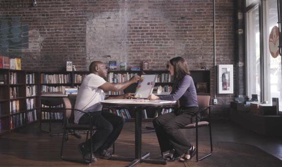 Image of Literacy Council volunteer helping a client improve his reading skills using a whiteboard and magnets