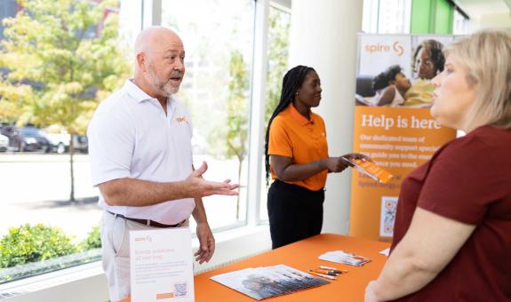 Image of a male Spire employee and female Spire employee helping a Spire customer get assistance with their bill