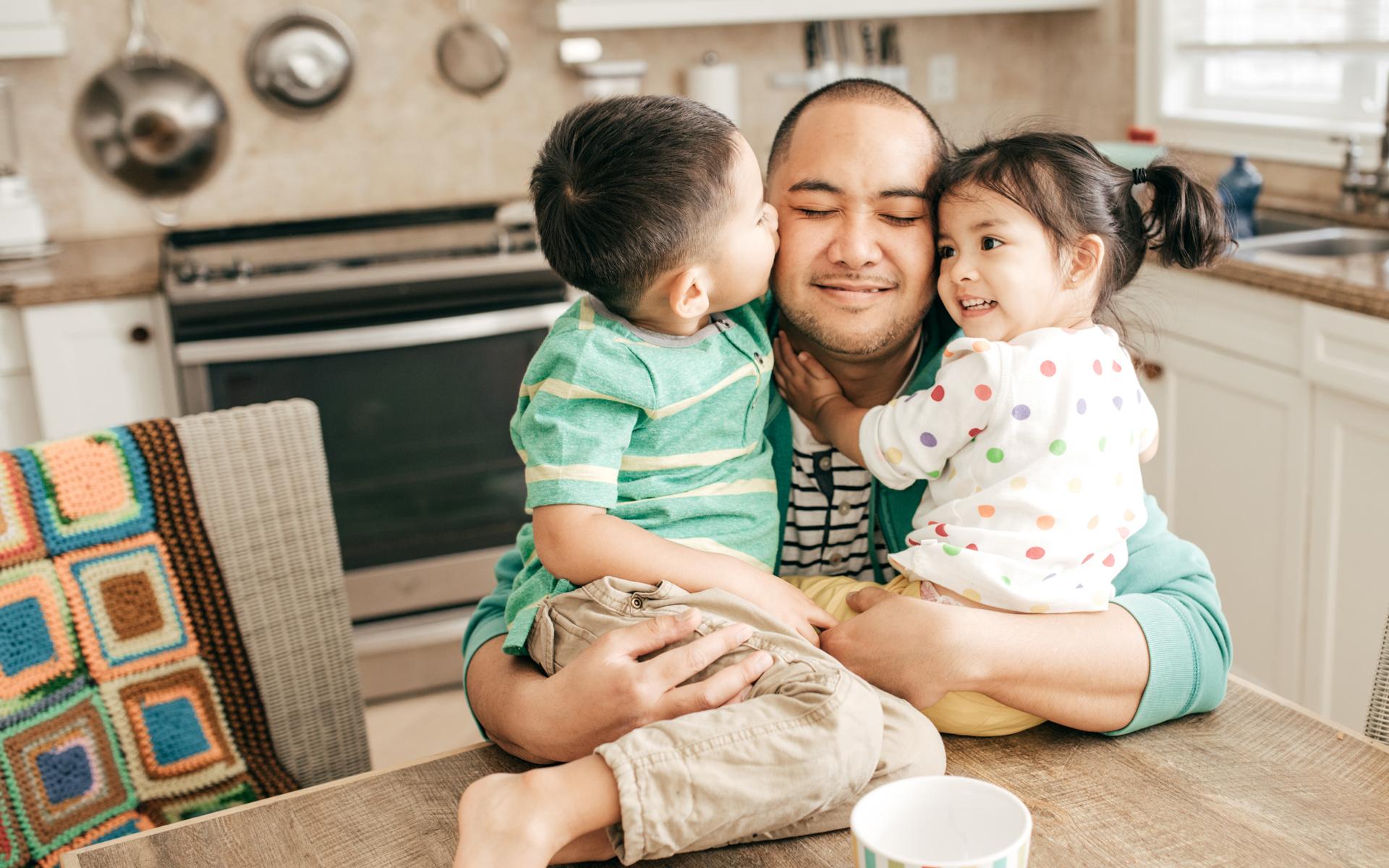 Family hugging in kitchen