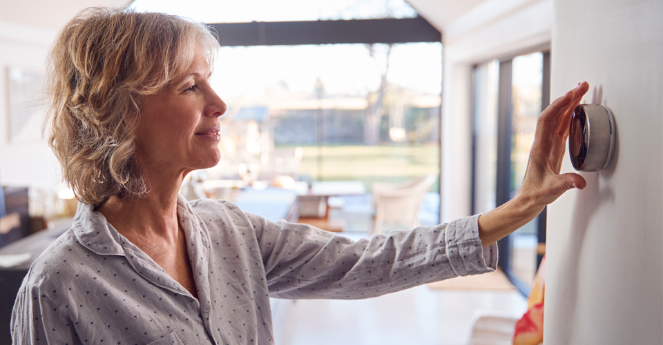 Woman adjusting smart home thermostat