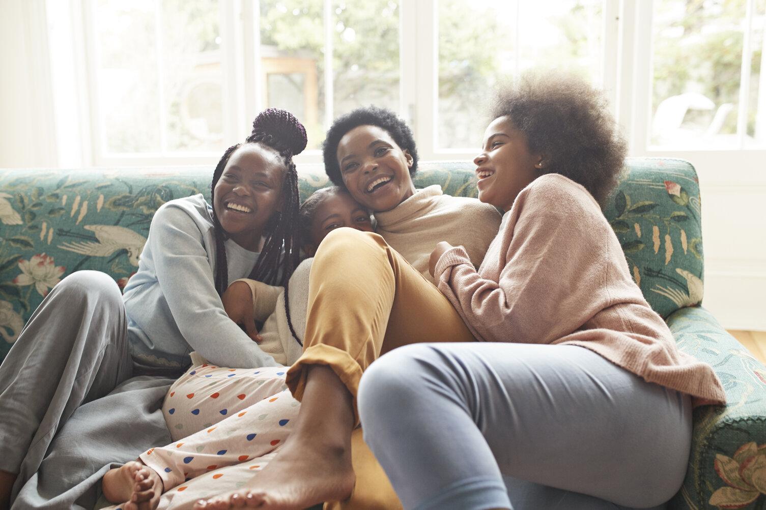 Image of: Family of mom and daughters snuggling on couch