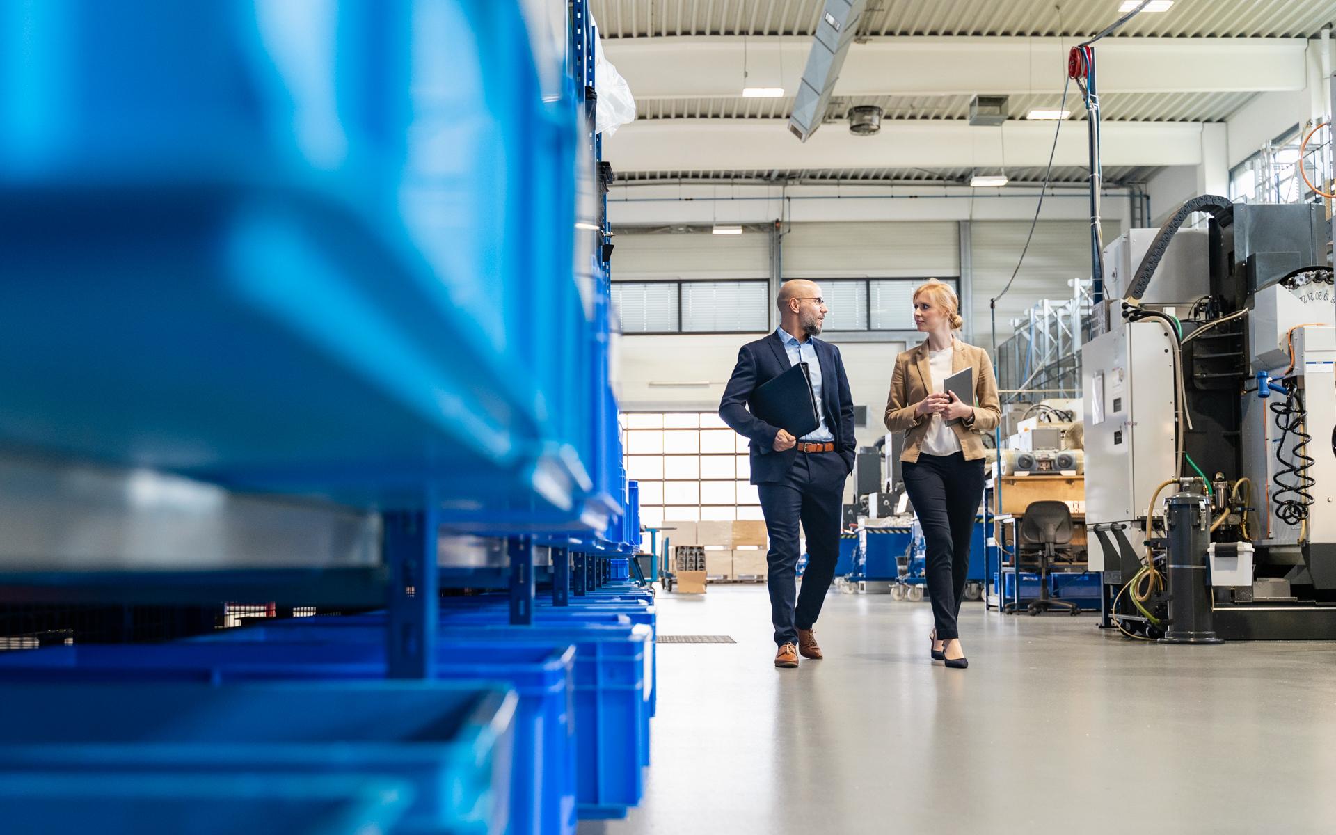 Image of man and woman walking across a factory floor