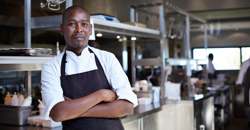 Image of restaurant owner in front of commercial kitchen
