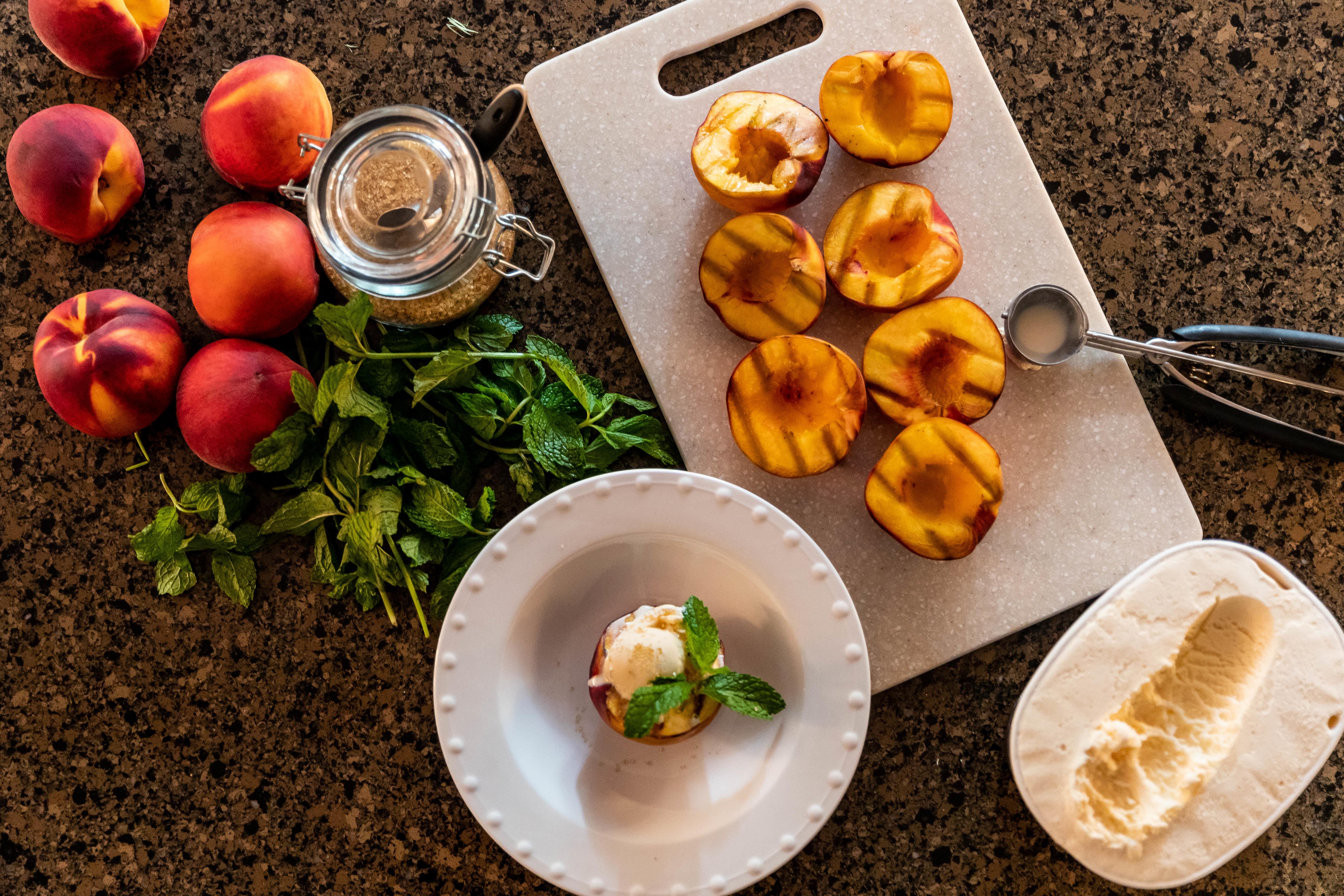 grilled peaches laid out with ice cream and other ingredients 