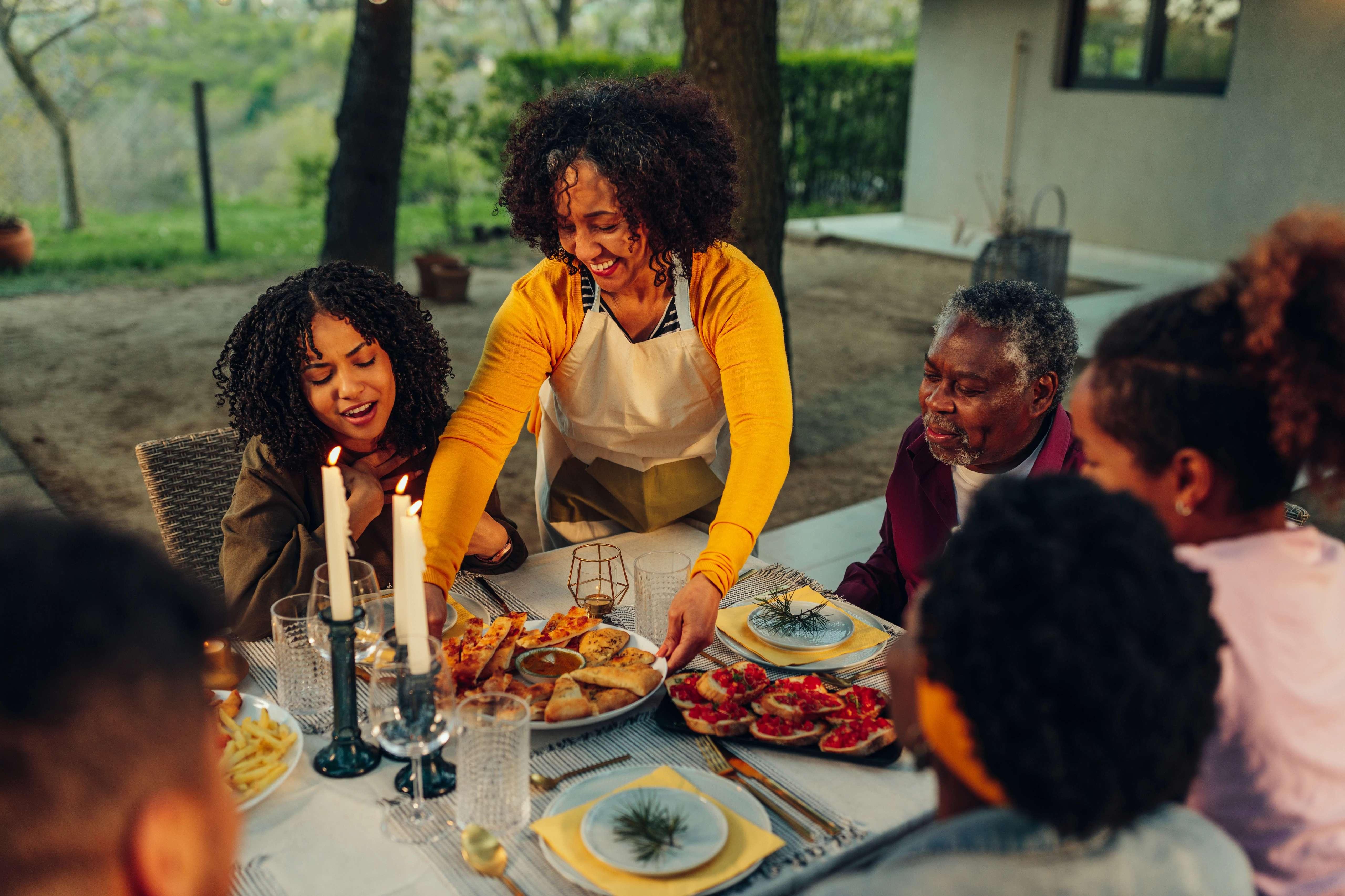 image of family enjoying an outdoor cozy dinner in the fall