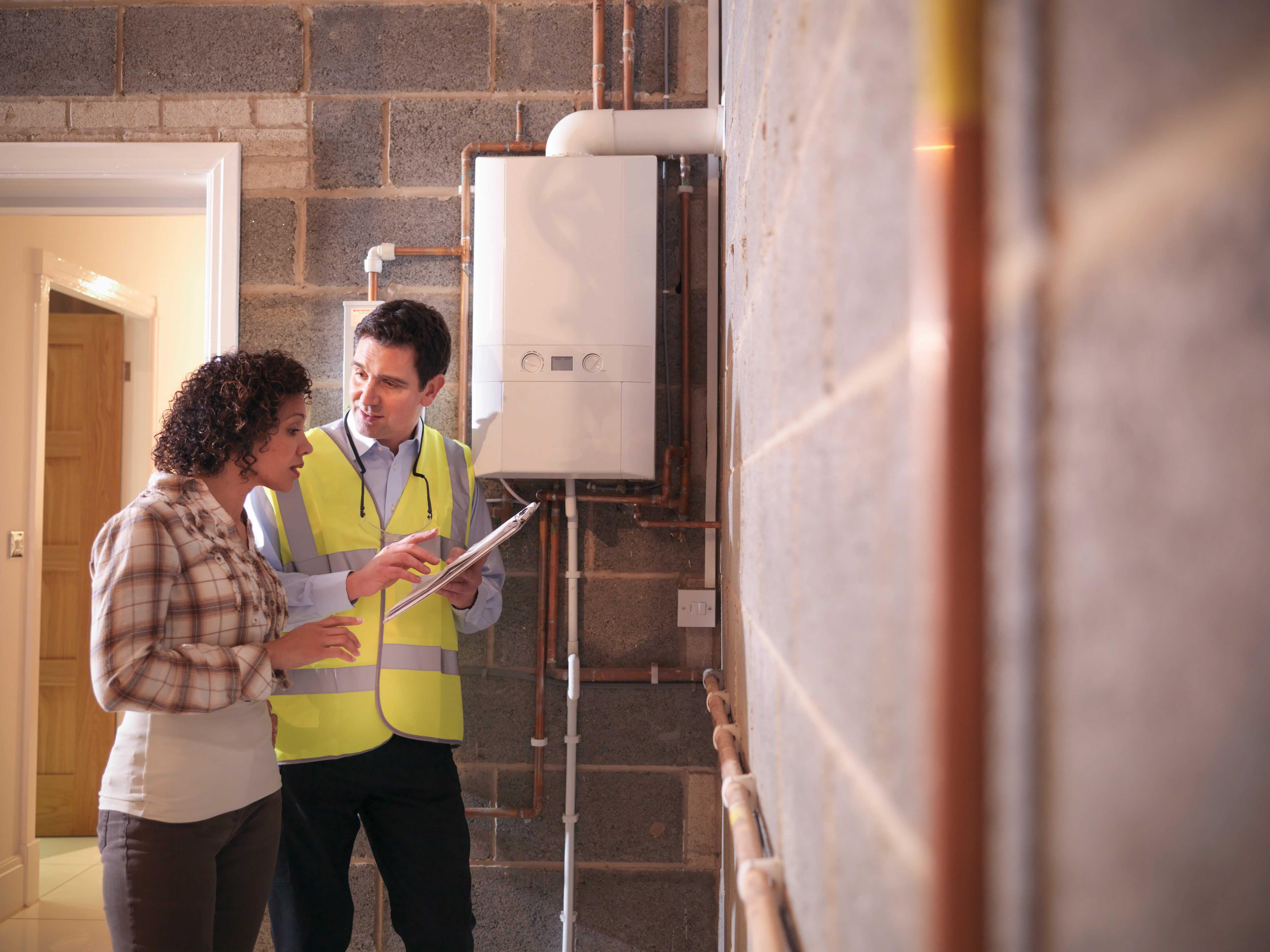 Image of a contractor standing with a customer talking about tankless water heaters