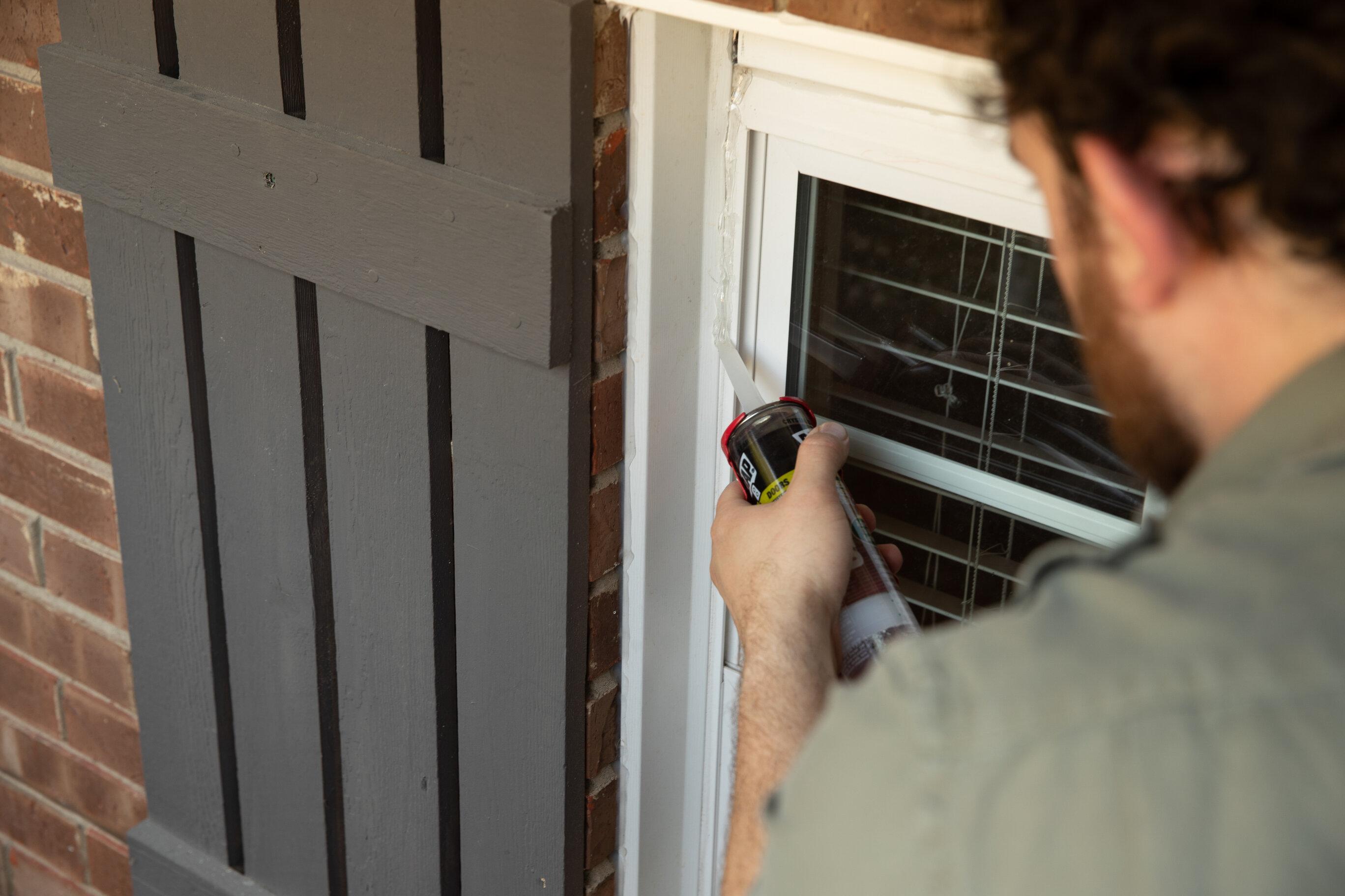 Image of man caulking his windows