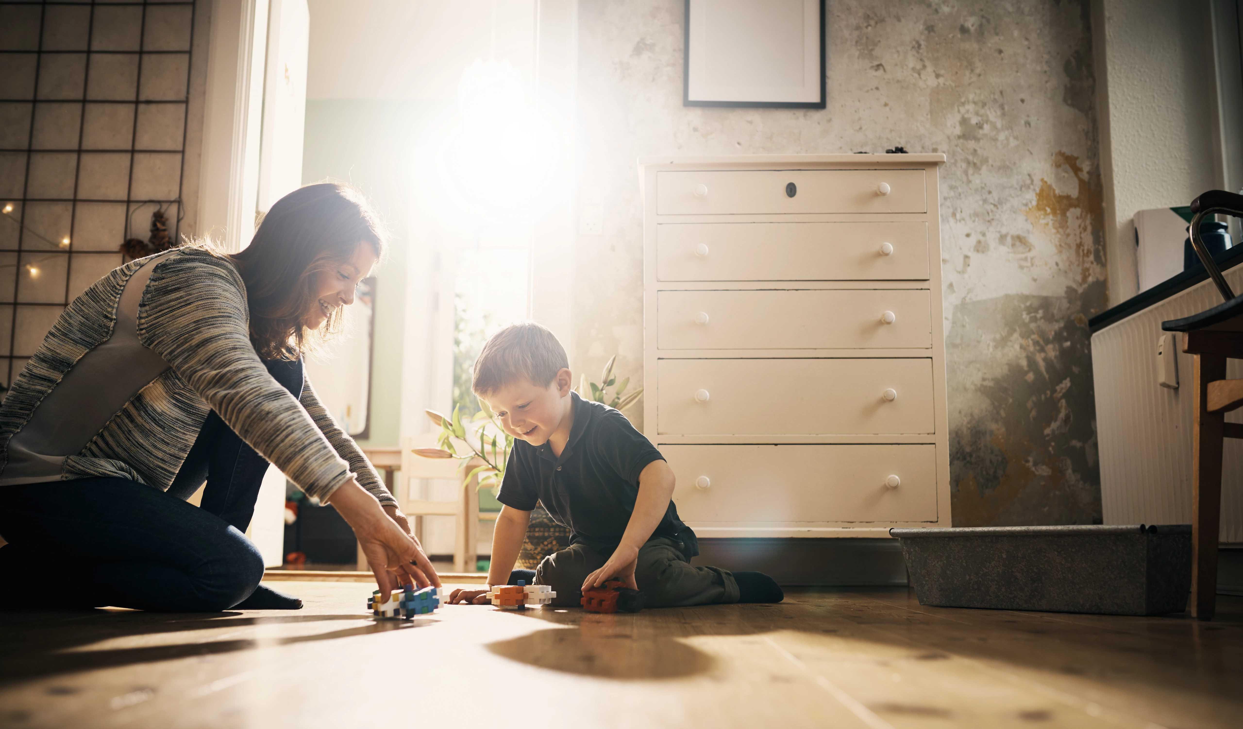 Image of a mother and child on the floor in a sunlit room