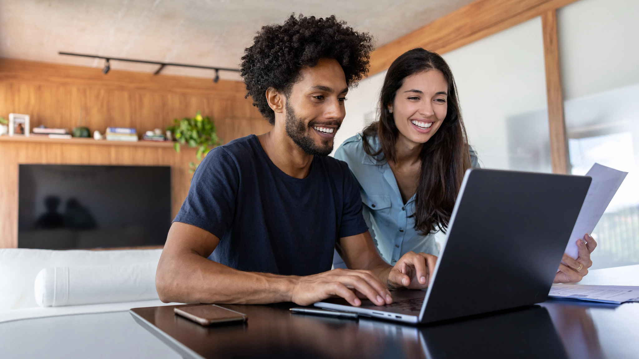 Image of a couple looking at their computer and smiling