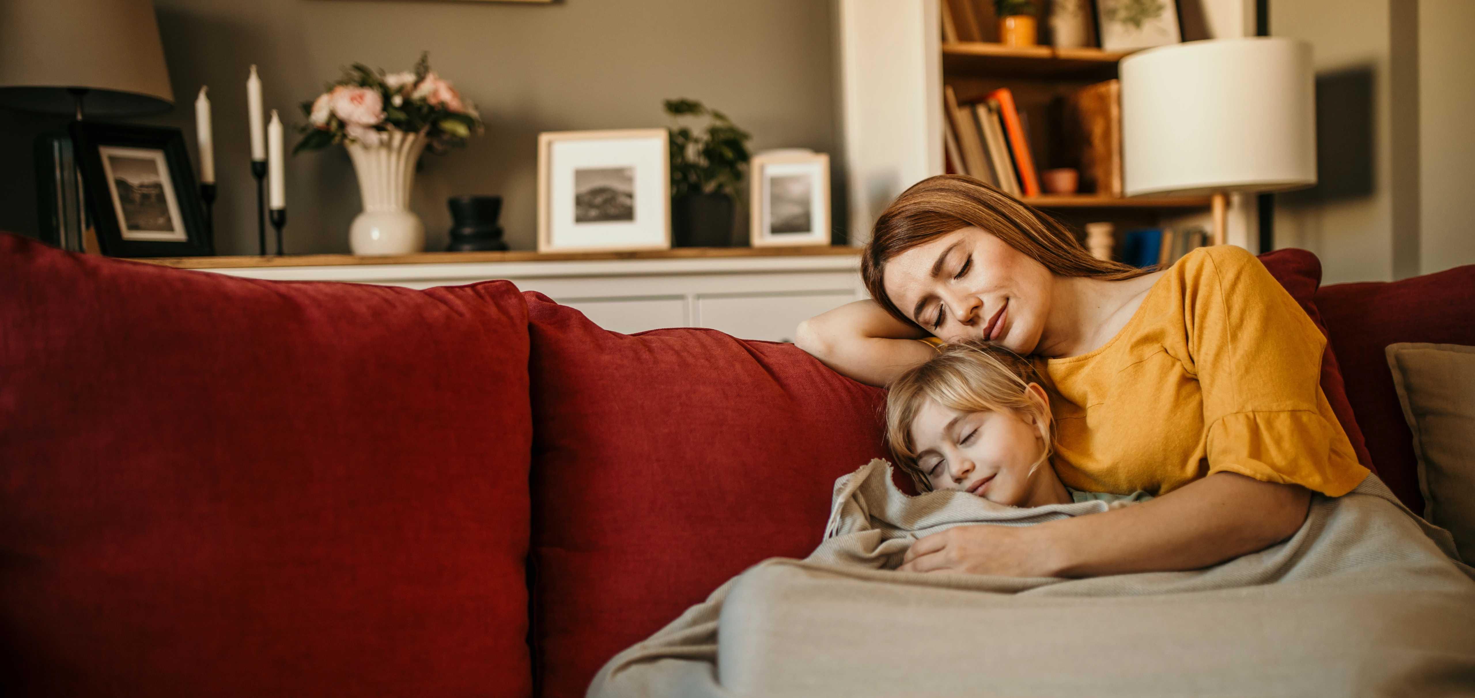 Image of mother and daughter snuggling on the couch
