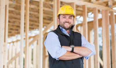 Image of contractor standing in front of wood at homebuilding