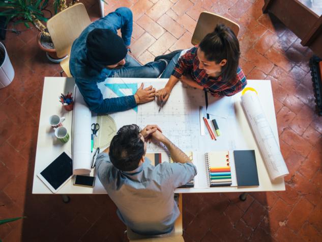 Image of builders collaborating with blueprints