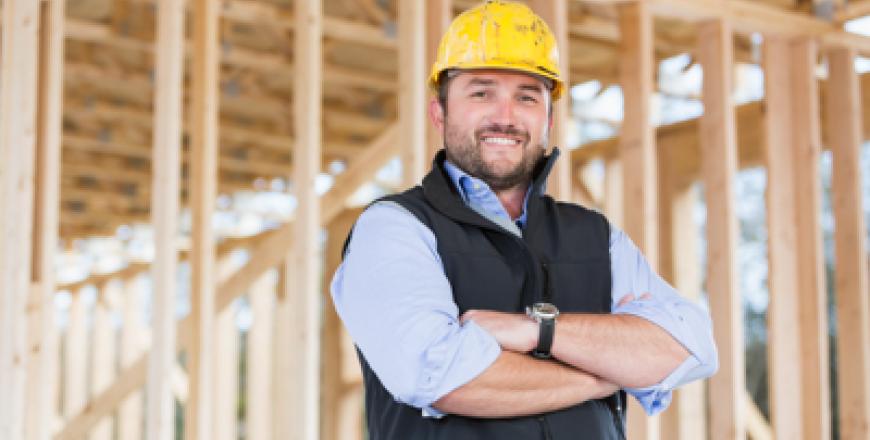 Image of contractor standing in front of wood at homebuilding