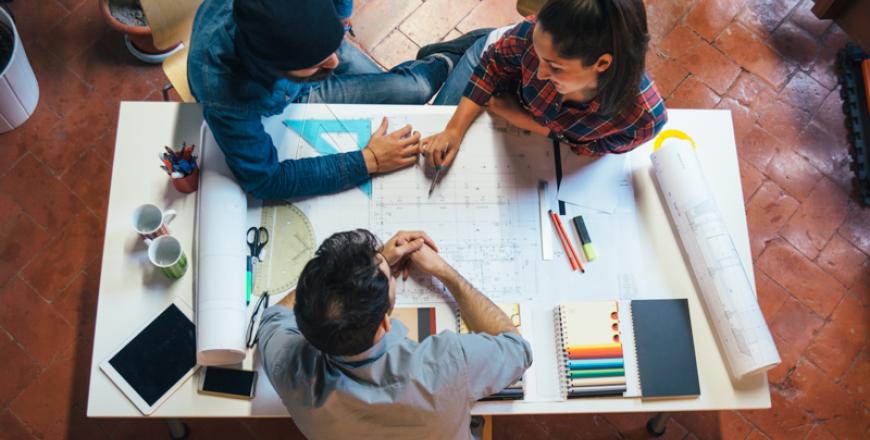 Image of builders collaborating with blueprints