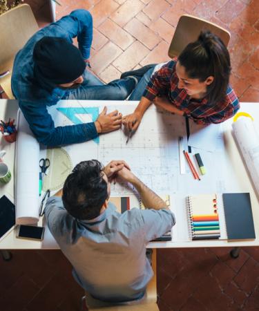 Image of builders collaborating with blueprints