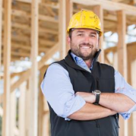 Image of contractor standing in front of wood at homebuilding