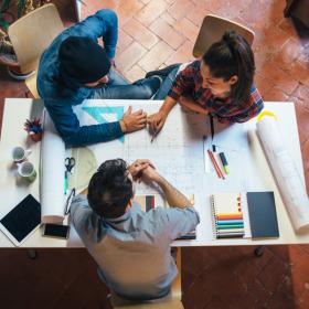 Image of builders collaborating with blueprints